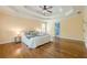 Inviting main bedroom featuring hardwood floors, a tray ceiling with ceiling fan, and a comfortable bed at 3440 Canyon Oak Way, Cumming, GA 30041