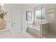 Bathroom featuring a tiled glass enclosed shower, soaking tub, and a vanity with a white countertop at 92 Sheryl Way, Loganville, GA 30052