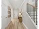 Bright hallway with wood floors, stairs with black iron railing, and a small table with a lamp at 92 Sheryl Way, Loganville, GA 30052