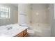 Well-lit bathroom with white tiled tub, oak vanity, and neutral wall color at 1214 Tyne Way, Stone Mountain, GA 30088