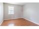 A spare bedroom with neutral walls and wood-look flooring features a window at 1214 Tyne Way, Stone Mountain, GA 30088