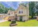 Back of the house with a well-manicured lawn, trees, and a neutral color scheme at 1214 Tyne Way, Stone Mountain, GA 30088