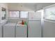 This laundry room has a washer, a dryer, and a refrigerator near natural light from windows at 2055 Anderson Se Dr, Smyrna, GA 30080
