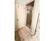 A neutral tiled bathroom featuring a glass shower door and linen storage at 4846 Twin Lakes Trl, Atlanta, GA 30360