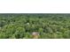 An aerial view reveals a home secluded within a vast, dense forest, ensuring a private retreat at 5276 Beechwood Ct, Marietta, GA 30068