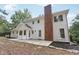 Backyard view showcases the home's brick chimney, stone patio, and white exterior siding at 5276 Beechwood Ct, Marietta, GA 30068