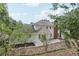 Tree-lined backyard view of home featuring white siding, brick chimney, and stone patio at 5276 Beechwood Ct, Marietta, GA 30068
