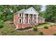 A traditionally styled brick home showcasing white columns and shutters, with a meticulously maintained lawn at 5276 Beechwood Ct, Marietta, GA 30068