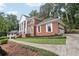 Traditional brick home with attached garage and columned portico, set amidst lush greenery and mature trees at 5276 Beechwood Ct, Marietta, GA 30068