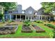 Beautiful backyard featuring raised garden beds, a lush lawn, and a covered patio ideal for outdoor living at 1178 Chambord Ne Way, Brookhaven, GA 30319