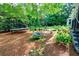 Backyard view featuring a trampoline, swing, landscaped stream, and vibrant garden at 1178 Chambord Ne Way, Brookhaven, GA 30319