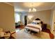 Comfortable bedroom featuring a decorative chandelier, chair and bench, and a walk-in closet with ample space at 1178 Chambord Ne Way, Brookhaven, GA 30319