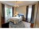 Bedroom featuring a queen-sized bed, soft lighting from a chandelier, and large windows with elegant curtains at 1178 Chambord Ne Way, Brookhaven, GA 30319