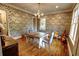 Dining room with decorative wallpaper, wood floors, a dining table, and an array of guitars at 1178 Chambord Ne Way, Brookhaven, GA 30319