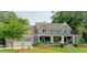 Charming gray two-story home boasts a landscaped yard, covered porch, and an attached three-car garage at 1178 Chambord Ne Way, Brookhaven, GA 30319