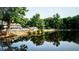 A picturesque view of the clubhouse overlooking the lake, reflecting the surrounding trees and sky at 1178 Chambord Ne Way, Brookhaven, GA 30319