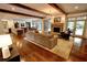 Bright living room with hardwood floors, exposed beams, and a cozy fireplace with a view to the kitchen and dining room at 1178 Chambord Ne Way, Brookhaven, GA 30319
