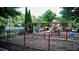 Community playground with swings, slides, and play area, surrounded by trees and fencing at 1178 Chambord Ne Way, Brookhaven, GA 30319