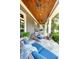 Covered porch features bluestone floor, wood ceilings, and comfortable seating with blue cushions at 1178 Chambord Ne Way, Brookhaven, GA 30319