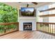 Outdoor back porch area with a fireplace, ceiling fan, and wall mounted TV at 3821 Chamblee Dunwoody Rd, Atlanta, GA 30341