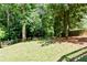 Spacious backyard featuring lush green grass, mature trees and a wood fence at 3821 Chamblee Dunwoody Rd, Atlanta, GA 30341