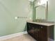 Bathroom features a dark wood vanity, light green walls and tile flooring at 3821 Chamblee Dunwoody Rd, Atlanta, GA 30341