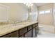 Bathroom with dual sinks, dark wood cabinetry, and a granite countertop at 3821 Chamblee Dunwoody Rd, Atlanta, GA 30341