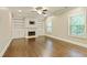 Comfortable living room featuring hardwood floors, a cozy fireplace, built-in shelves, and ample natural light at 3821 Chamblee Dunwoody Rd, Atlanta, GA 30341