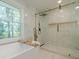 Bright bathroom featuring a soaking tub with gold fixtures near a window and a modern glass shower at 4446 Huntington Cir, Atlanta, GA 30338