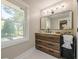 Bathroom with a wood cabinet vanity, marble floors, a large mirror, and a bright window at 4446 Huntington Cir, Atlanta, GA 30338