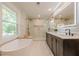 Luxurious bathroom with freestanding tub, marble walls, and modern vanity with gold accents at 4446 Huntington Cir, Atlanta, GA 30338