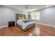 Well-lit bedroom featuring hardwood floors, a gray tufted headboard, and a modern ceiling fan at 4446 Huntington Cir, Atlanta, GA 30338