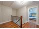 Upstairs hallway featuring hardwood floors, iron railing, and a view into the adjacent bedroom at 4446 Huntington Cir, Atlanta, GA 30338