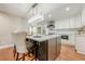 Stunning kitchen with a black island, white cabinets, stainless steel appliances, and a glamorous crystal chandelier at 4446 Huntington Cir, Atlanta, GA 30338