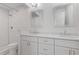 Bathroom boasts double vanity with white cabinets, white granite countertop, and walk-in shower at 1824 Westwood Sw Ave, Atlanta, GA 30310