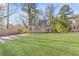 Beautiful house with a large, well-manicured front lawn, trees, and a long driveway leading to the side of the house at 1824 Westwood Sw Ave, Atlanta, GA 30310