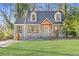 Charming home featuring a landscaped front yard and inviting light-blue front door beneath a wooden awning at 1824 Westwood Sw Ave, Atlanta, GA 30310