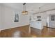 Spacious eat-in kitchen with stainless steel appliances, a modern light fixture, and hardwood floors at 1824 Westwood Sw Ave, Atlanta, GA 30310