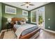 Green bedroom featuring a leather platform bed, many windows, ceiling fan, and balcony access at 408 Townly Ct, Alpharetta, GA 30009