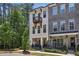 Stylish townhome features a private balcony and covered patio, complemented by lush greenery and a black metal fence at 408 Townly Ct, Alpharetta, GA 30009