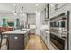 An open kitchen features gray cabinets, stainless steel appliances, and an island with seating and sink at 408 Townly Ct, Alpharetta, GA 30009