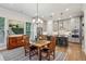 A kitchen features gray cabinets, stainless steel appliances, a large island with seating, and an adjacent dining area at 408 Townly Ct, Alpharetta, GA 30009