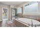 This bright bathroom features a soaking tub, walk-in shower with glass door and a large window at 147 Longleaf Dr, Canton, GA 30114