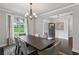 Elegant dining room with hardwood floors, modern lighting fixture, and a view of the well-manicured lawn at 147 Longleaf Dr, Canton, GA 30114