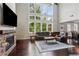 Bright living room with hardwood floors, stone fireplace, and soaring windows that provide lots of natural light at 147 Longleaf Dr, Canton, GA 30114