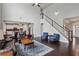 Bright, open living room with hardwood floors, staircase, and view into the kitchen area at 147 Longleaf Dr, Canton, GA 30114