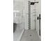 Modern walk-in shower with gray-and-white tiled wall, rain showerhead, and glass enclosure at 1521 Sylvan Sw Rd, Atlanta, GA 30310