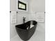 Freestanding black soaking tub with black hardware near marble wall with bright window at 1521 Sylvan Sw Rd, Atlanta, GA 30310