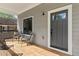 Inviting front porch featuring wood decking, stylish seating, and a modern front door with a window at 1521 Sylvan Sw Rd, Atlanta, GA 30310