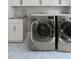 Efficient laundry area with modern machines and sink, combines style and functionality, and unique patterned floors at 1521 Sylvan Sw Rd, Atlanta, GA 30310